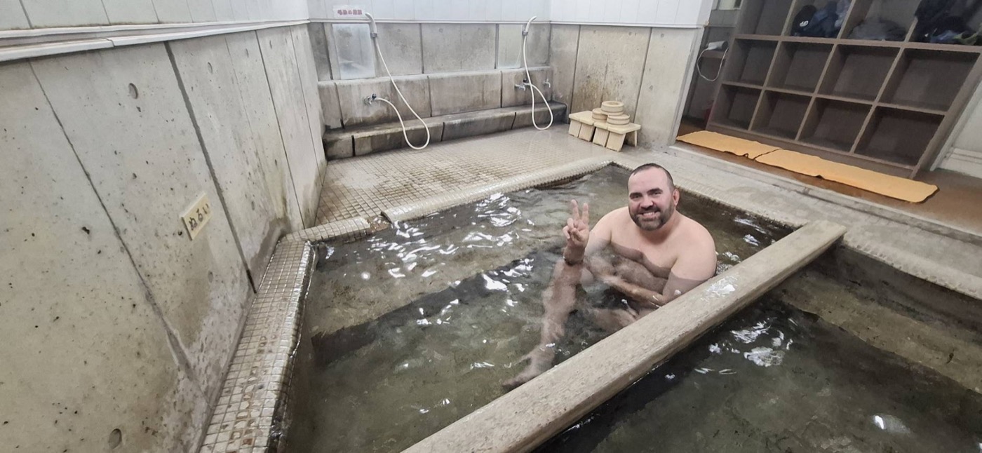 Michal Mazur testing the quality of a city-run onsen in Beppu as a municipal onsen operations monitor.