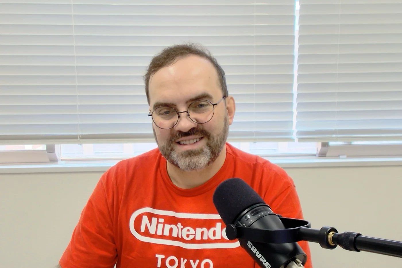 Michał Mazur w koszulce Nintendo Tokyo nagrywa podcast.